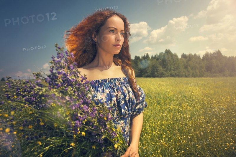 Caucasian woman holding flowers in rural field