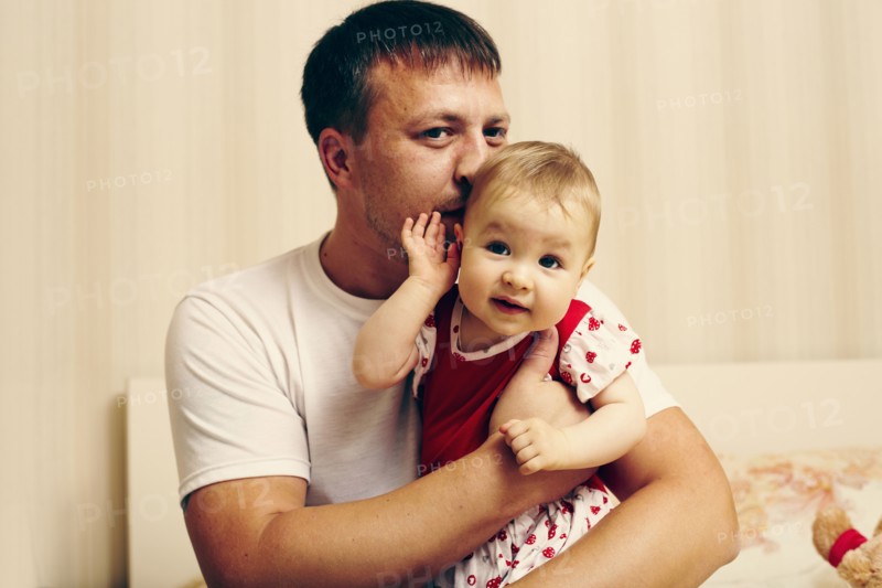 Caucasian father kissing baby daughter