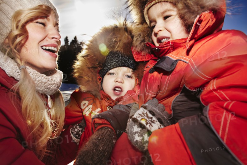 Mother and sons laughing outdoors