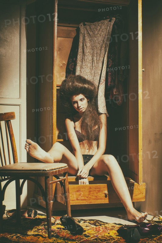 Caucasian woman sitting in wardrobe wearing underwear