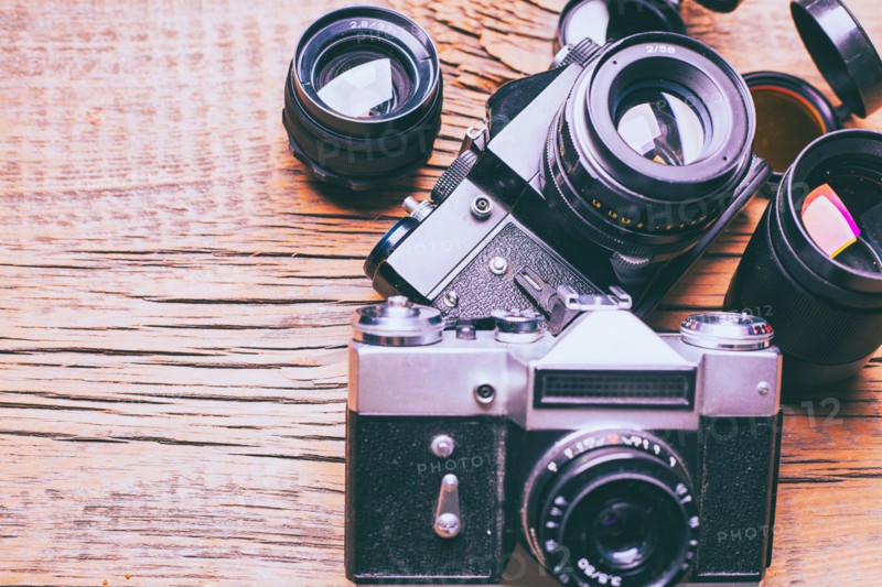 Cameras and lenses on wooden table