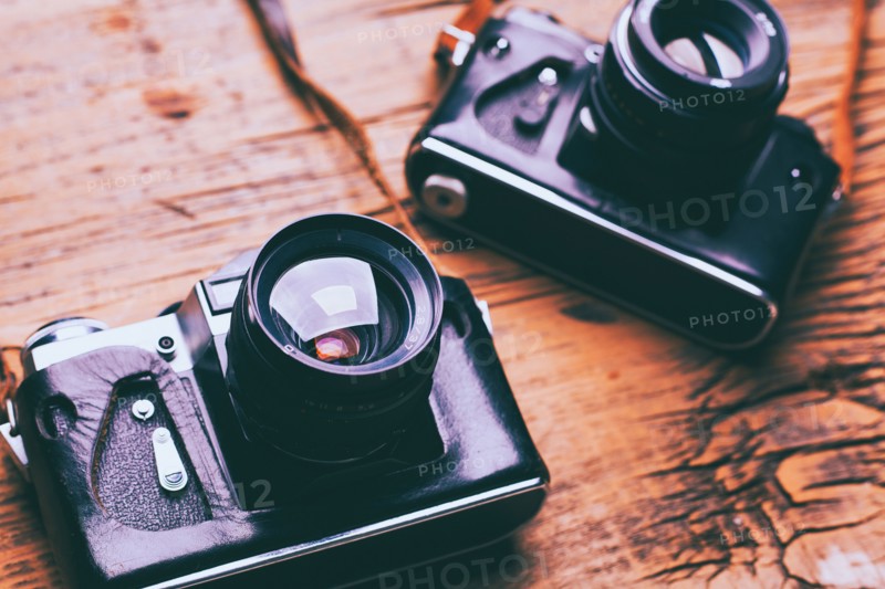 Cameras and straps on wooden table