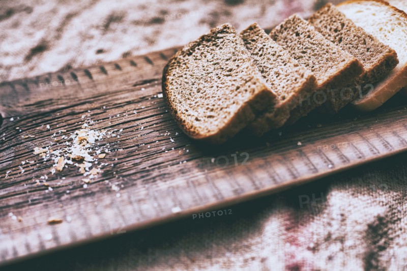 Close up of slices of bread and crumbs on wooden tray