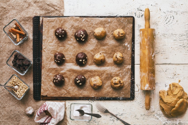 Cookie dough on baking sheet near rolling pin and ingredients