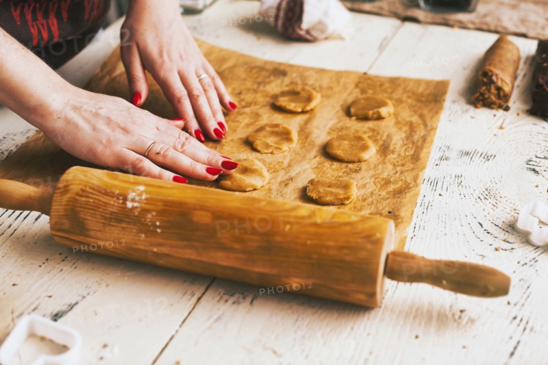 Hands of woman pressing cookie dough on baking sheet