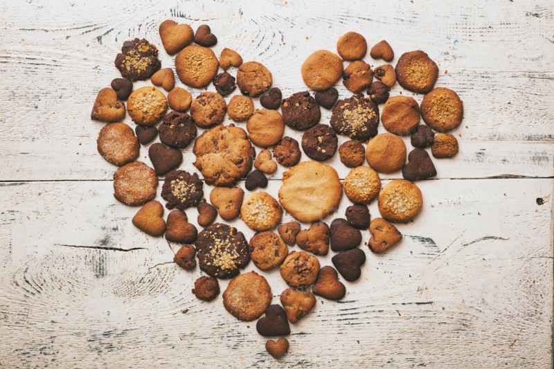 Variety of cookies on wooden table in heart-shape