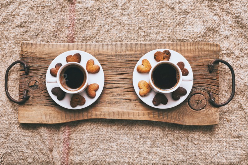 Coffee and heart-shape cookies on wooden tray