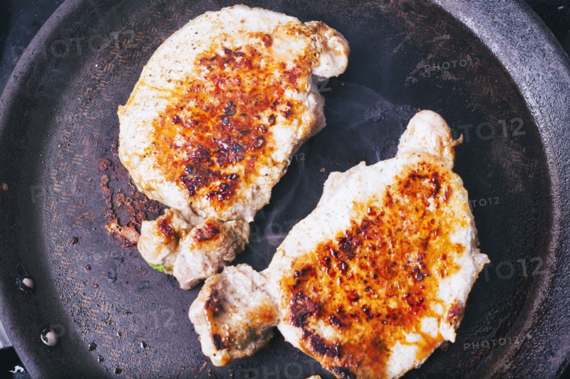 Pork chops searing in pan