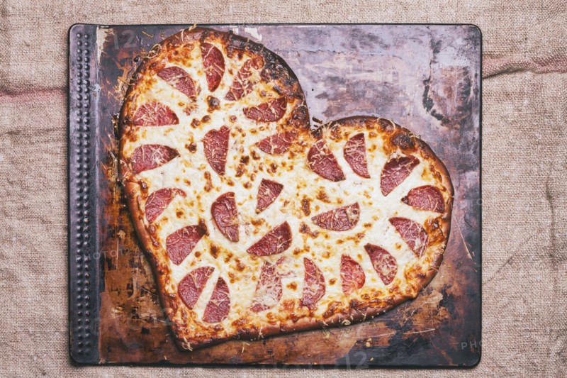 Heart-shaped pizza on pan