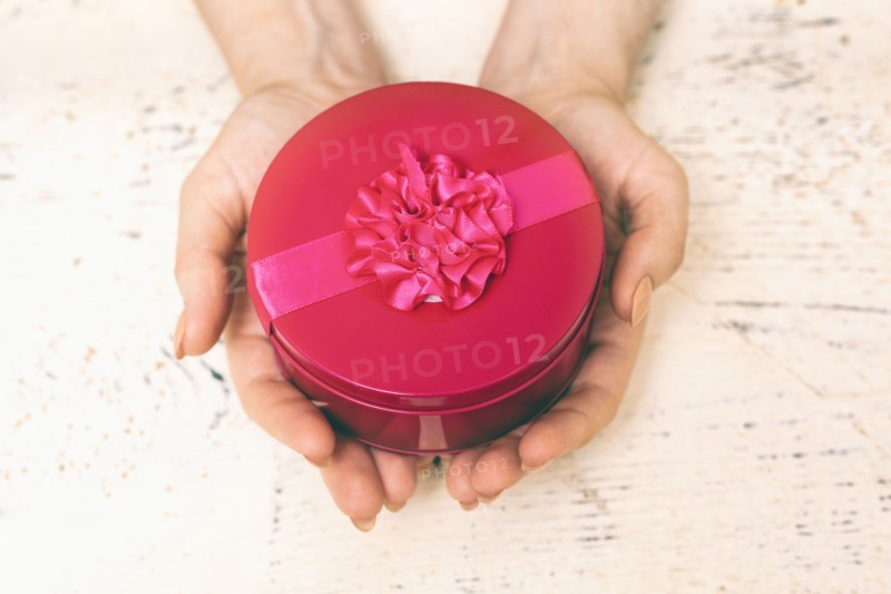 Hands of woman holding round gift box