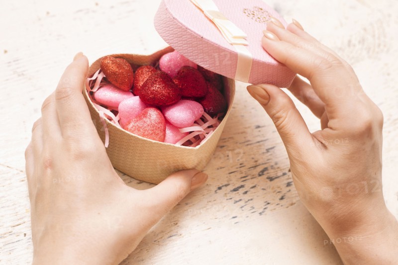 Hands of woman opening valentine gift box