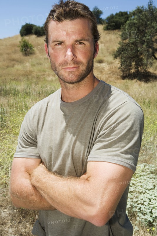 Serious man standing in remote field