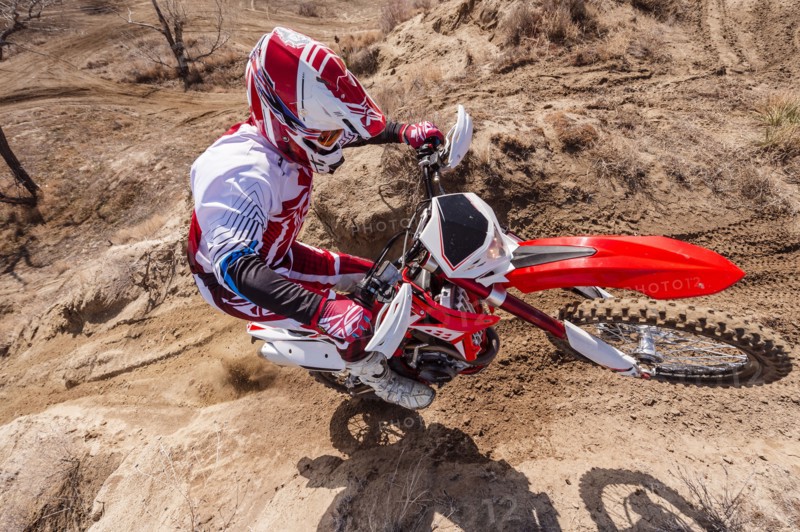 Motorcyclist riding dirt bike on hillside
