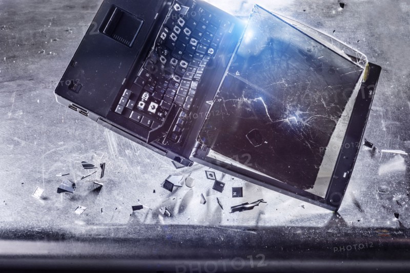 Laptop falling and shattering on desk