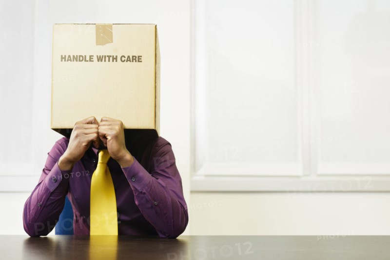 Black businessman with box over his head