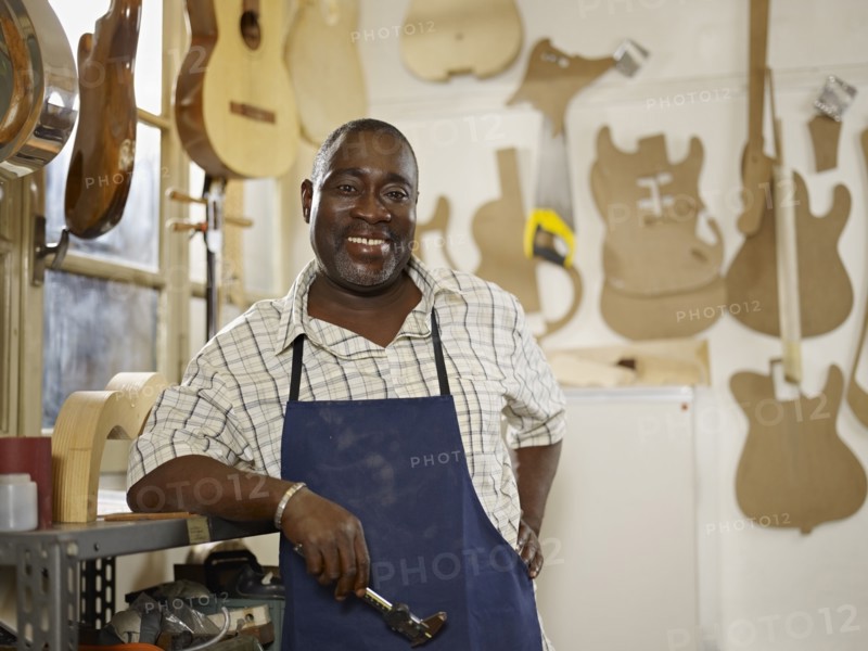Black craftsman in guitar workshop