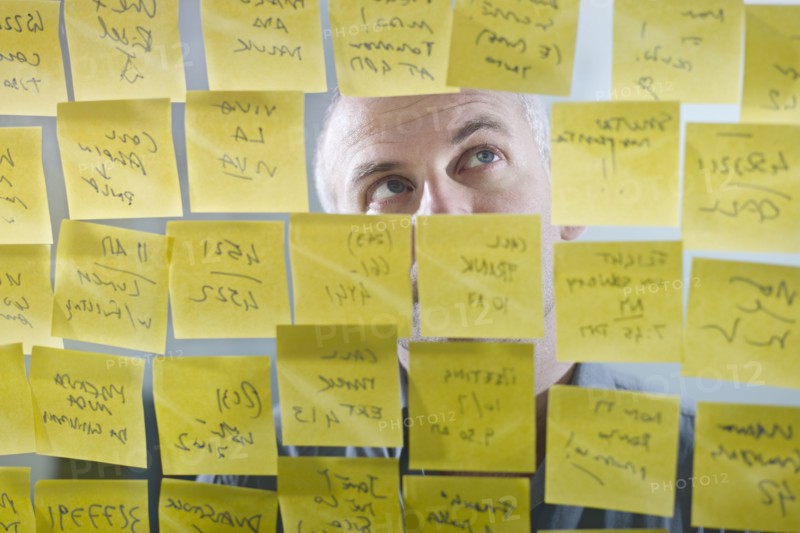 Caucasian businessman looking at adhesive notes on wall