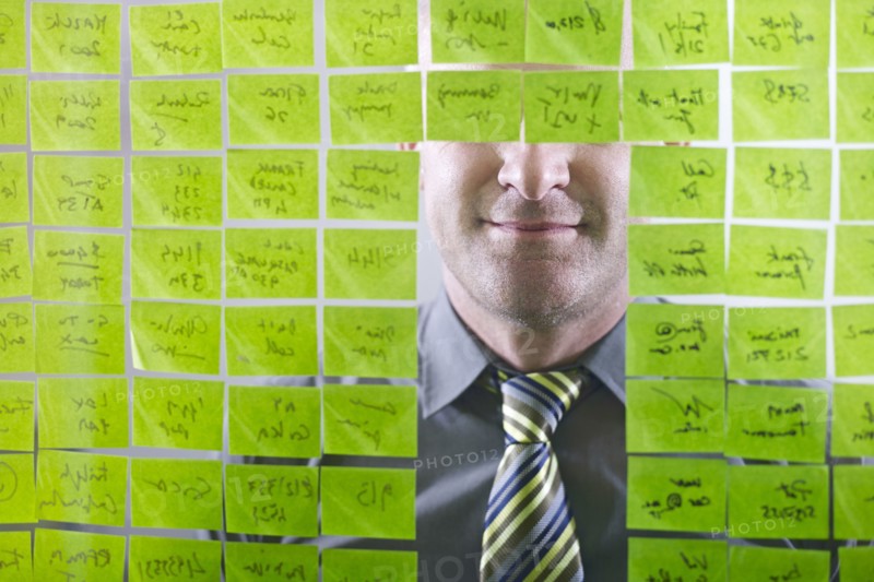 Caucasian businessman looking at adhesive notes on wall
