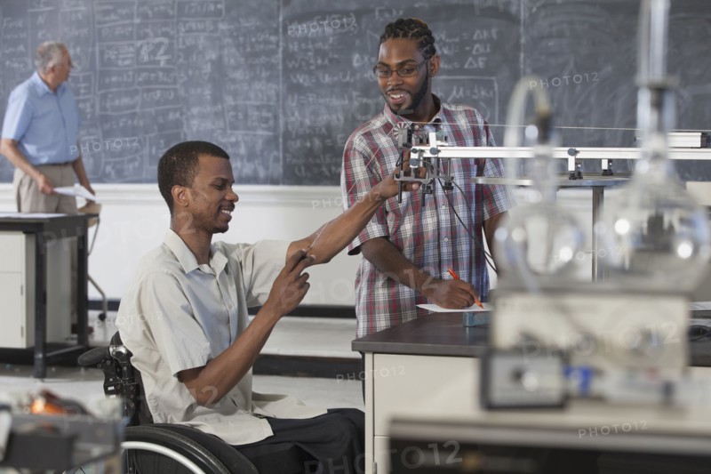 Paraplegic student working with classmate in science classroom
