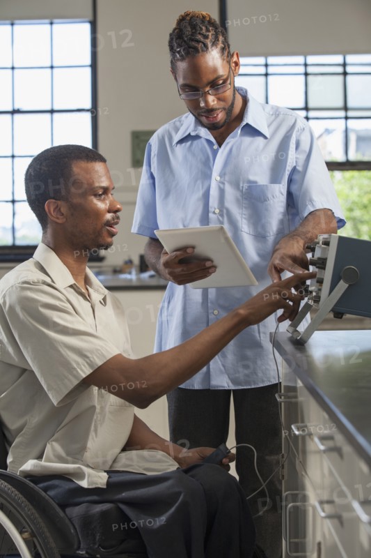 Paraplegic student and classmate working in science classroom