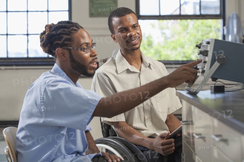 Paraplegic student and classmate working in science classroom