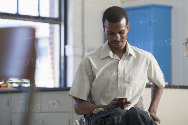 African American paraplegic man using cell phone