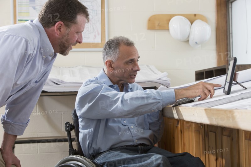 Caucasian architects using digital tablet in office