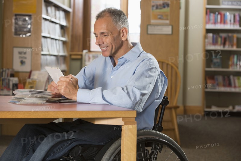 Caucasian man examining dvds in library