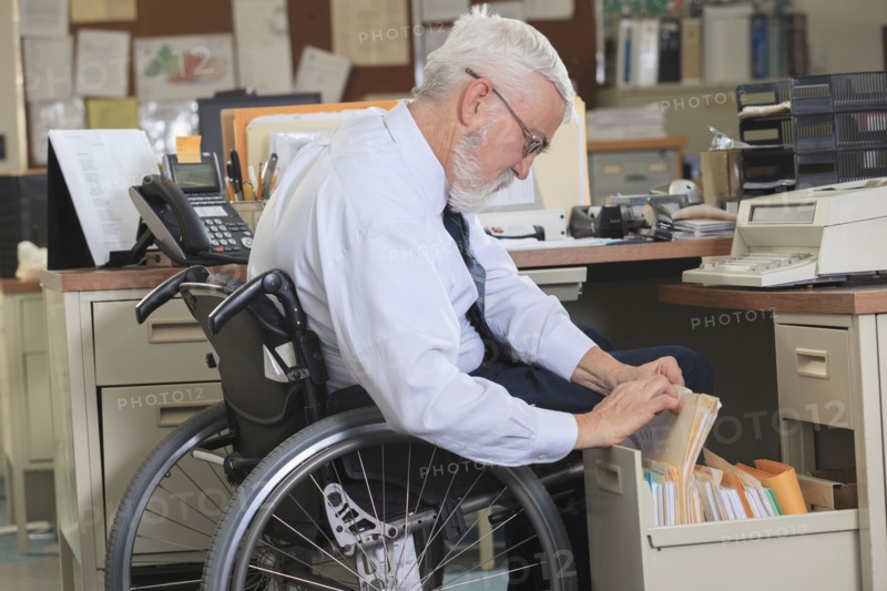 Caucasian businessman filing papers in office