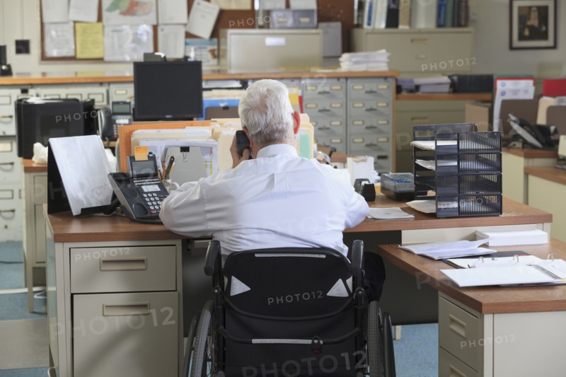 Caucasian businessman talking on phone in office