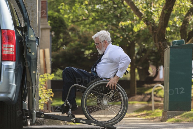 Caucasian businessman in wheelchair entering van
