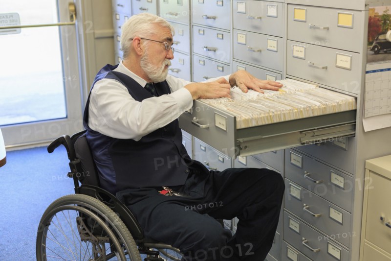 Caucasian businessman filing papers in office