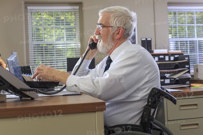 Caucasian businessman talking on phone at desk