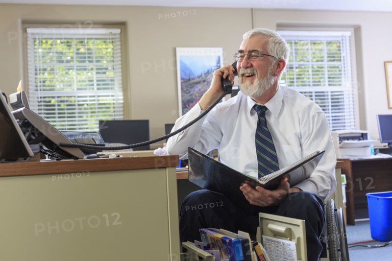 Caucasian businessman talking on phone at desk