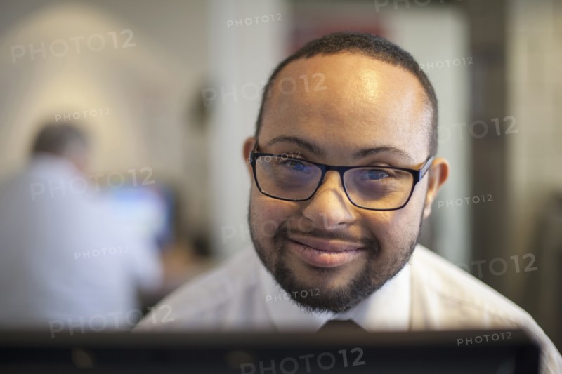 Mixed race businessman with down syndrome working on computer