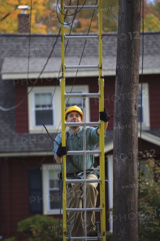 Caucasian worker climbing ladder