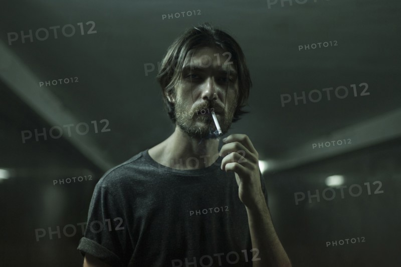 Caucasian man with beard smoking cigarette