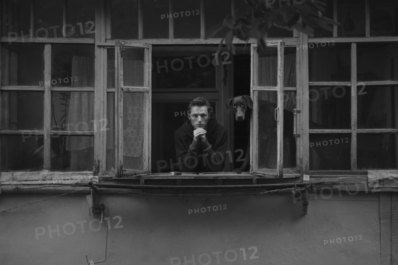 Caucasian man leaning in window with dog