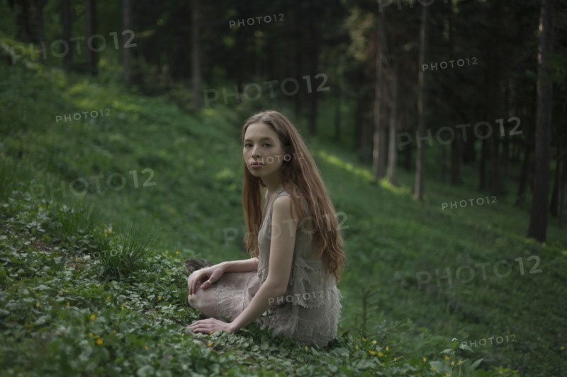 Serious Caucasian woman sitting on hill