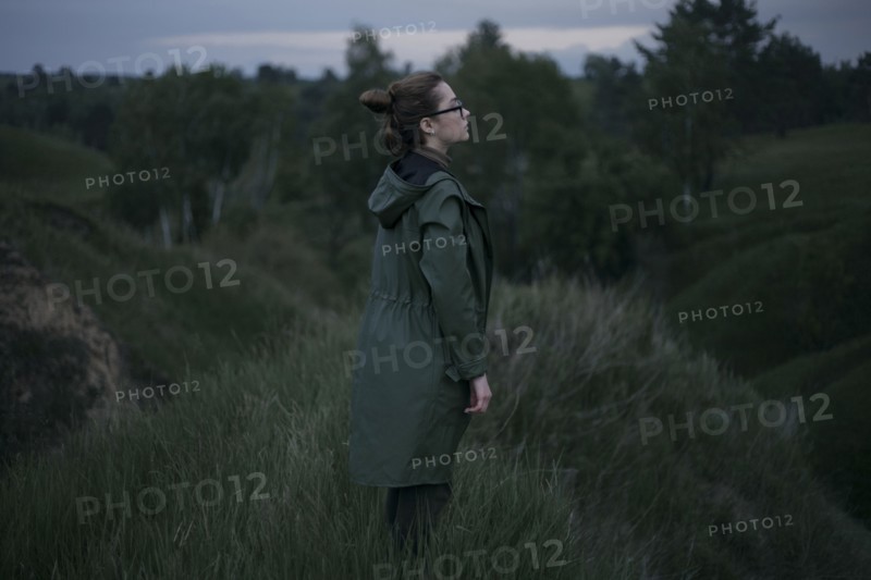 Pensive Caucasian woman standing on hill