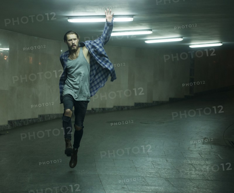 Carefree Caucasian man skipping in tunnel