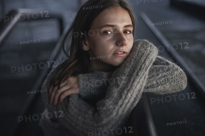 Portrait of serious Caucasian woman leaning on staircase railing