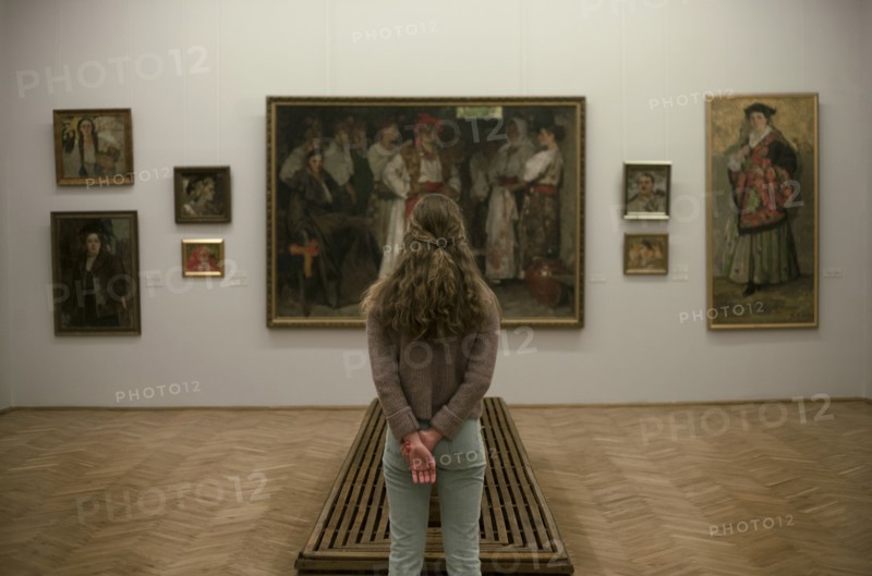 Caucasian teenage girl admiring paintings in museum