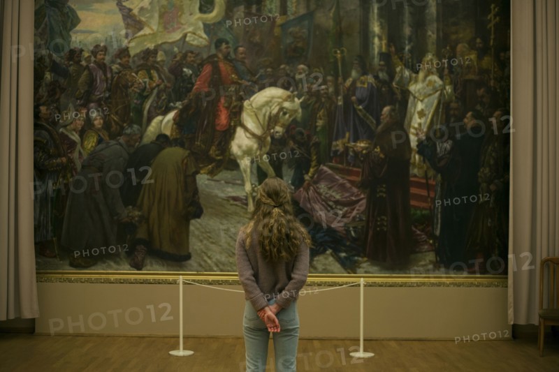 Caucasian teenage girl admiring painting in museum