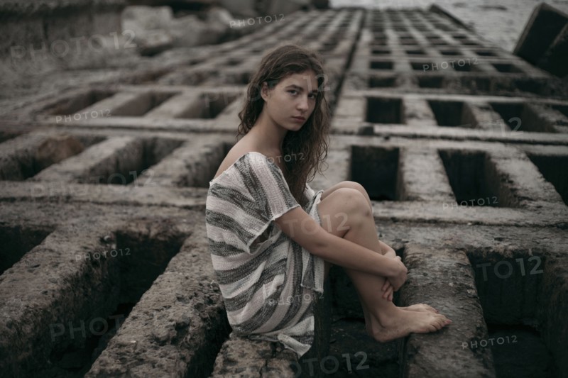 Portrait of Caucasian teenage girl sitting on structure