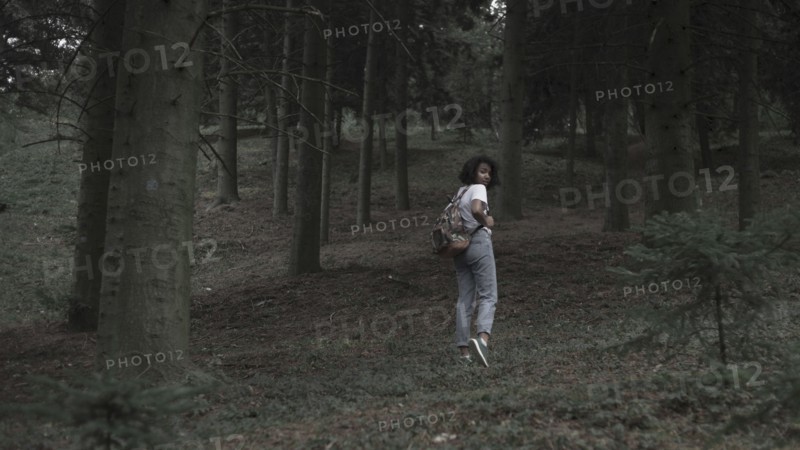 Fearful woman running in woods