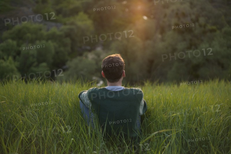 Caucasian man sitting in grass