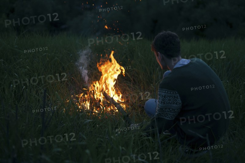 Caucasian man with campfire at night