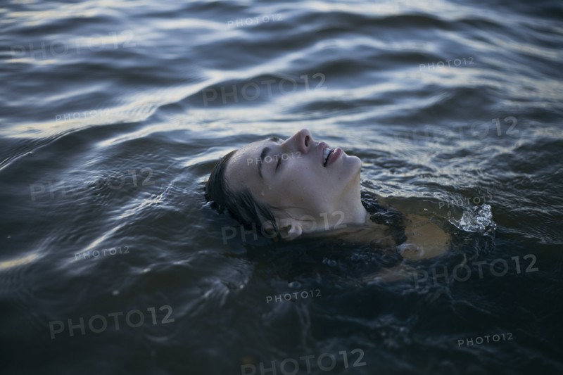 Caucasian woman floating in ocean with eyes closed