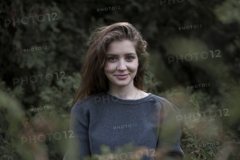 Portrait of smiling Caucasian teenage girl in woods